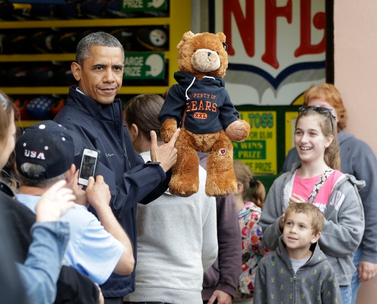 U.S. President Barack Obama holds up a stuffed bear that New Jersey Governor Chris Christie won at the boardwalk during their visit to Point Pleasant, NJ., on May 28, 2013.