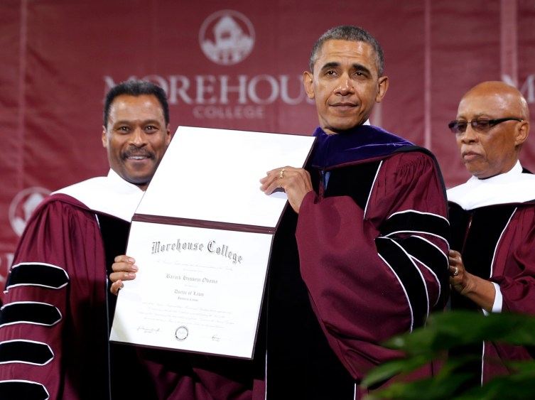 U.S. President Obama poses with honorary Doctor of Laws degree he received from Chairman of Board of Trustees Davidson and College President Wilson at graduation ceremony of class of 2013 at Morehouse College in Atlanta