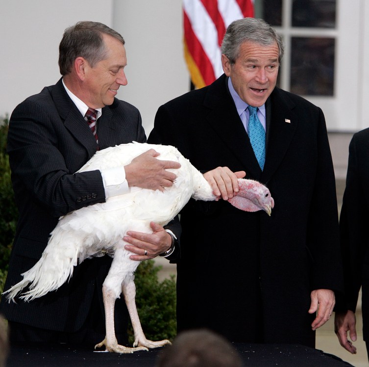 President George W. Bush, right, pets Flyer the turkey, held by Lynn Nutt, after giving the bird a Thanksgiving pardon in the Rose Garden of the White House on Wednesday, November 22, 2006.