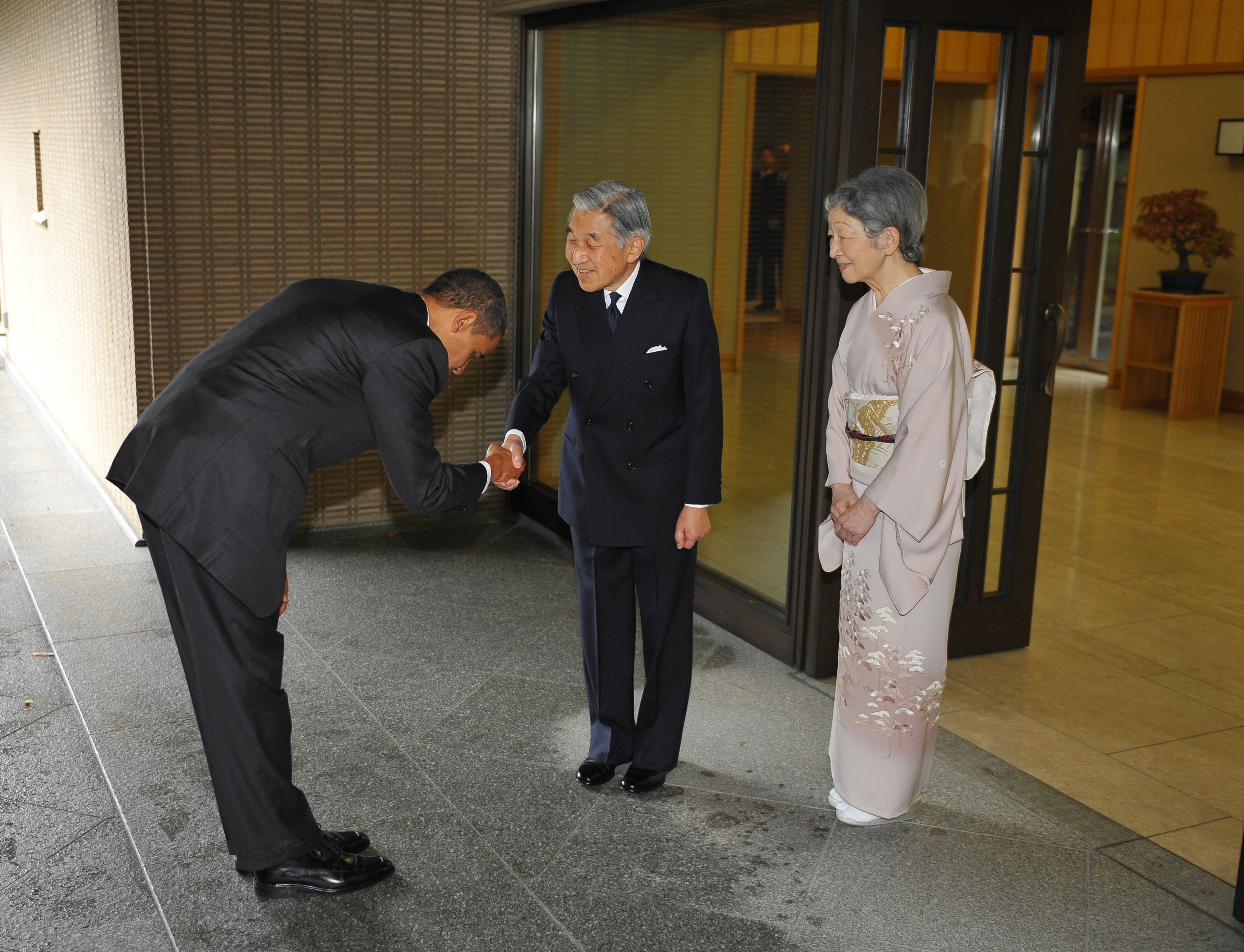 President Barack Obama bows as he shakes hands with Japanese Emperor Akihito and as Empress Michiko looks on upon Obama's arrival at the Imperial Palace in Tokyo on November 14, 2009.