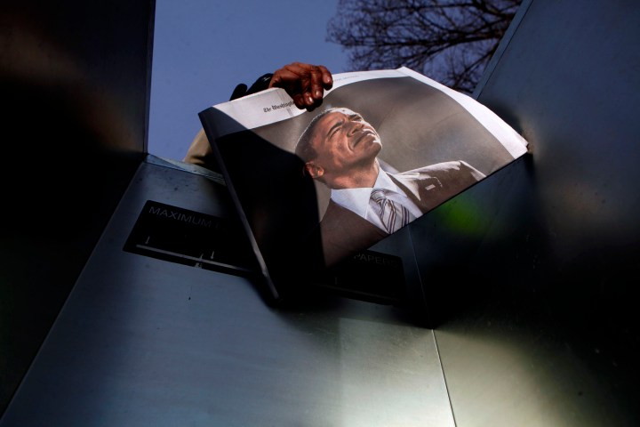 A woman sells newspapers with a picture of President Barack Obama on the National Mall for the ceremonial swearing-in on the West front of the Capitol in Washington, DC, on Jan. 21, 2013. 