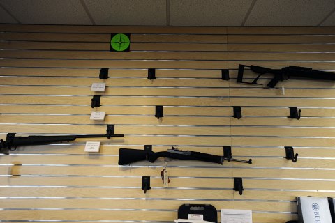 image: Rifles hang on a near empty display wall at Centennial Gun Store in Centennial, Colo., Dec. 20, 2012. 