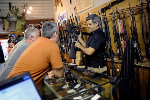A gun shop owner shows his last two AR-15 style rifles to a group of customers in Sarasota