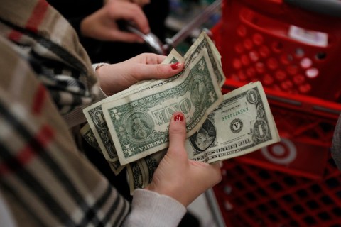 A customer counts her money while waiting in line to check out at a Target store on the shopping day dubbed "Black Friday" in Torrington