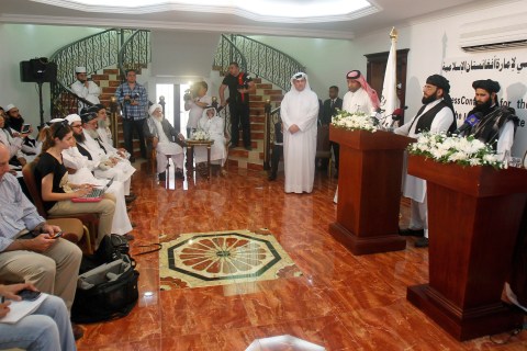 Naeem, a spokesman for the Office of the Taliban of Afghanistan, stands next to a translator speaking during the opening of the Taliban Afghanistan Political Office in Doha