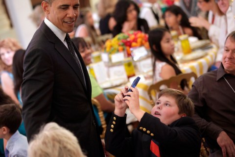 A boy takes pictures of U.S. President Obama at "Kids' State Dinner" in Washington