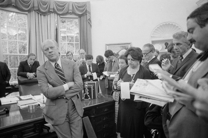 Helen Thomas, right, takes notes as President Ford, speaking to reporters, maintains that he has not used any privileges for his personal use, and is confident that he would be cleared of any wrongdoing by the Special Watergate Prosecutor, in Washington, September 1976. 