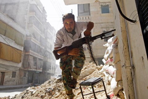 A Free Syrian Army fighter takes cover during clashes with Syrian Army in the Salaheddine neighbourhood of central Aleppo