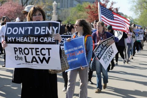 People rally as legal arguments over the Patient Protection and Affordable Care Act take place at the Supreme Court in Washington