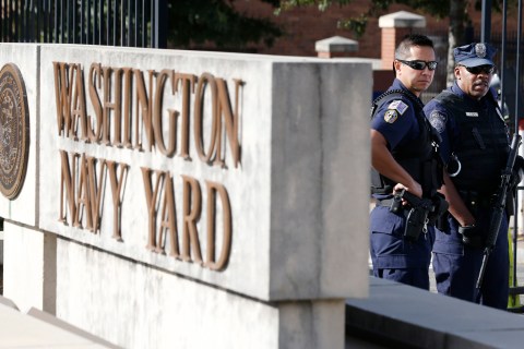 A Washington, DC Metropolitan police officer (L) and a Naval District Washington policemen (R) stand guard at the main gate of the Washington Navy Yard in Washington