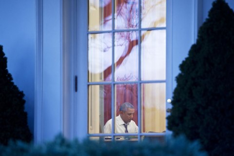 President Barack Obama works in the Oval Office of the White House on January 27, 2014 in Washington.