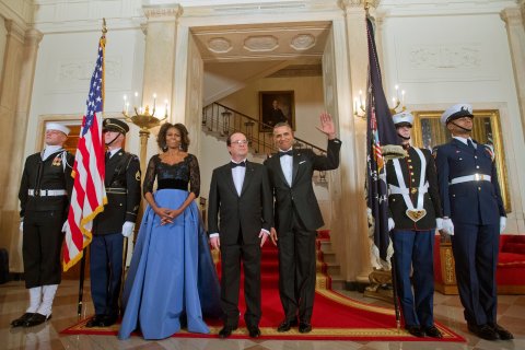 First Lady Michelle Obama and President Barack Obama with French President Francois Hollande, center, pose at the Grand Staircase as they arrive for a State Dinner, Tuesday, Feb. 11, 2014, at the White House in Washington. 