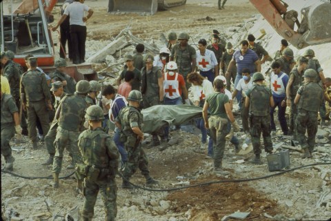 Marines and Red Cross workers carrying c