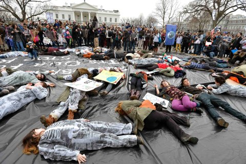 Environmentalists pretend to be dead on a black sheet symbolizing an oil spill as they rally in front of the White House and call on President Barack Obama to reject the Keystone XL oil pipeline, in Washington